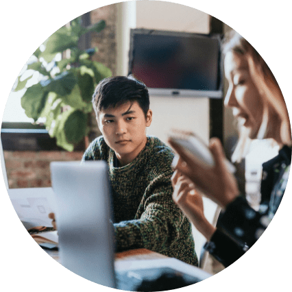 Man holding papers while in meeting with woman on laptop